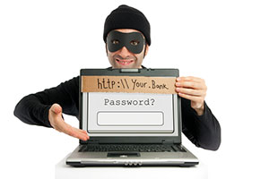 Person dressed as a stereotypical burglar holding a sign with a fake url and password field, symbolizing online phishing scams.